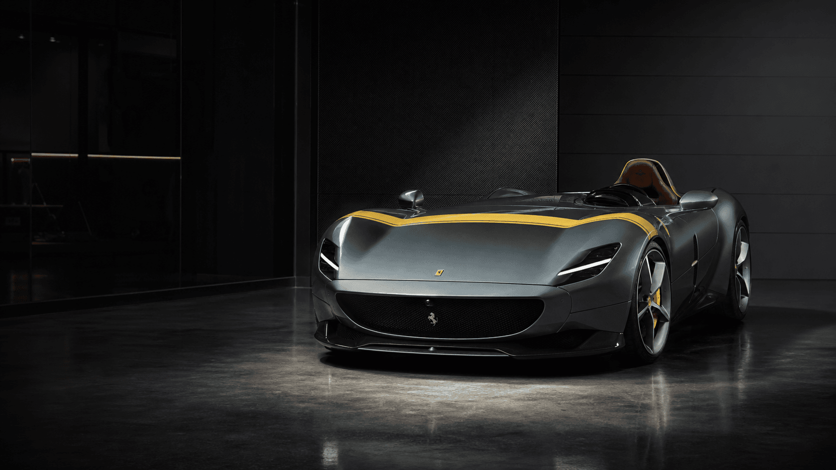 Ferrari Monza speedster with yellow hood stripe in a dark private advisory studio